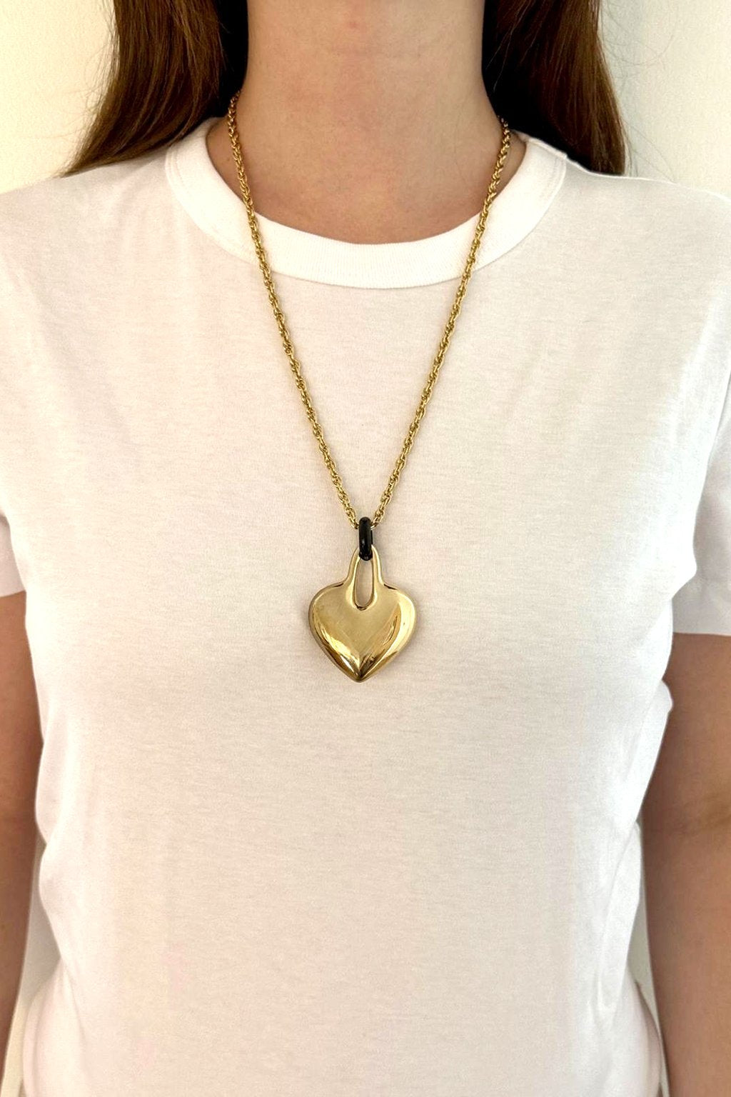 Charm cœur Maïon porté en pendentif sur une chaîne dorée