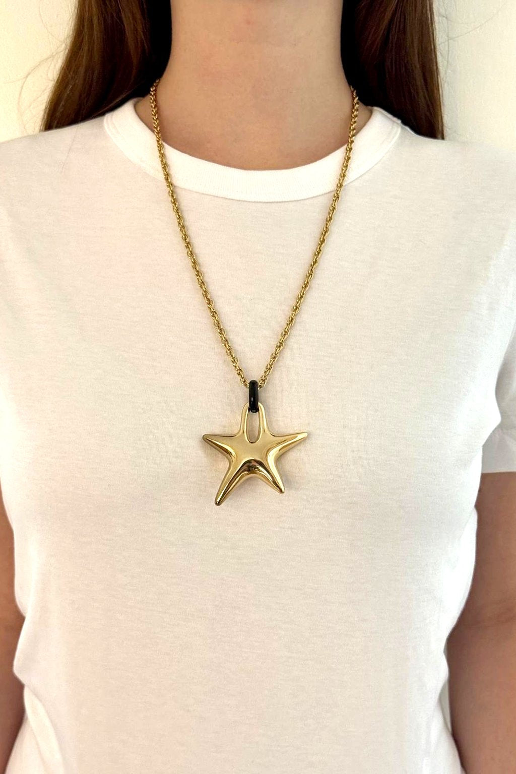 Charm étoile Maïon porté en pendentif sur une chaîne dorée